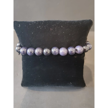Purple silver glittery beaded stone bracelet on black velvet cushion