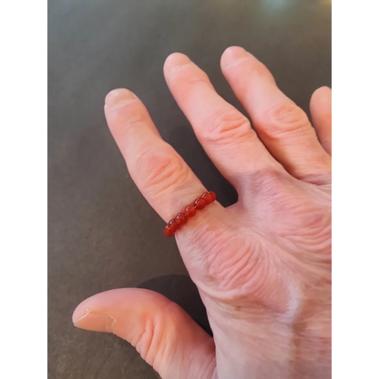 Delicate red beaded stone ring on finger from vibrant collection