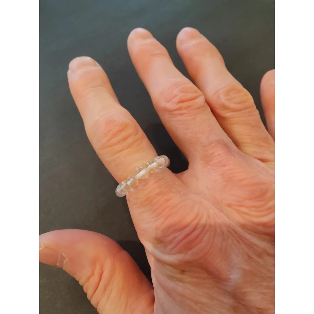 Delicate transparent beaded stone ring in vibrant colors on finger