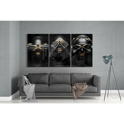 Black gold triptych glass wall art with abstract faces over gray sofa
