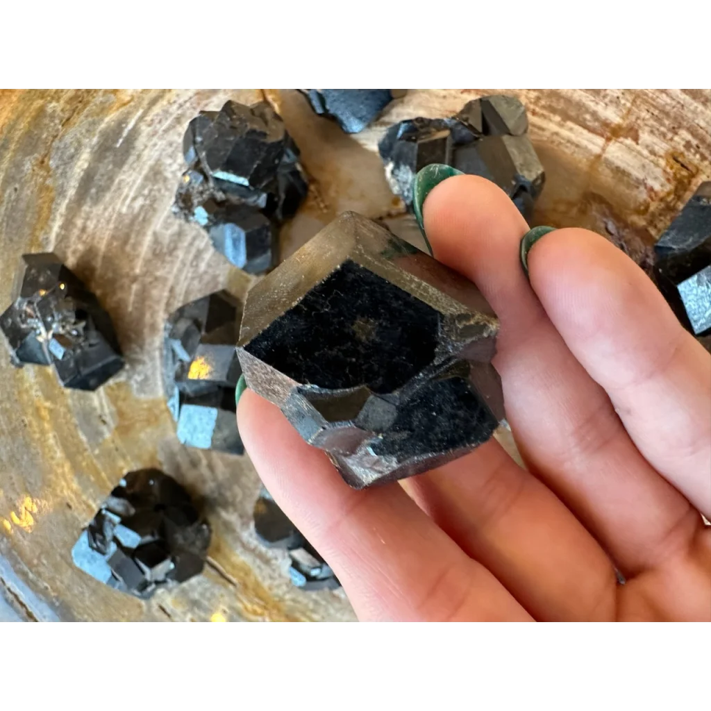 Hand holding stunning black melanite garnet crystal from Mali Africa
