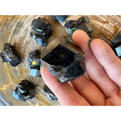 Hand holding stunning black melanite garnet crystal from Mali Africa