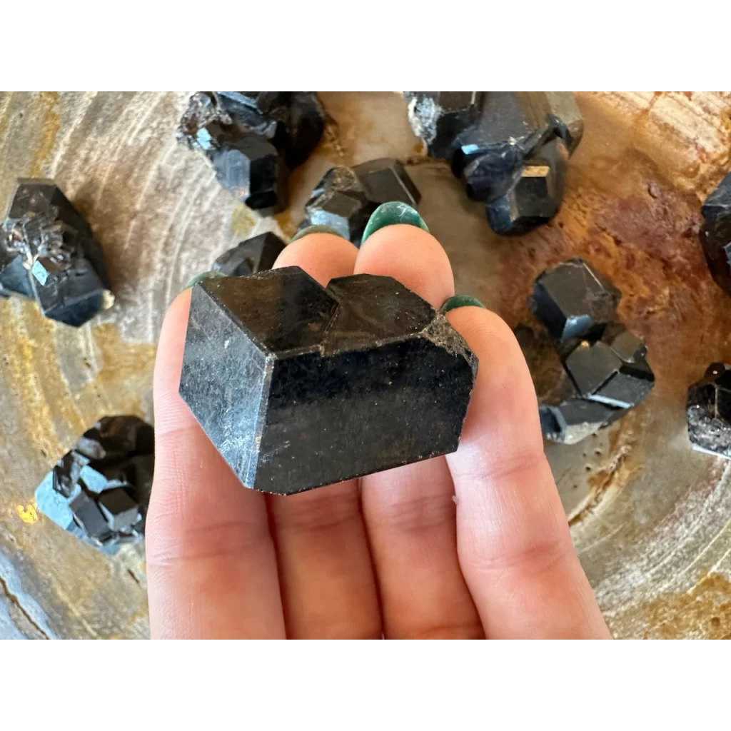 Hand holding stunning black melanite garnet crystal from Mali Africa