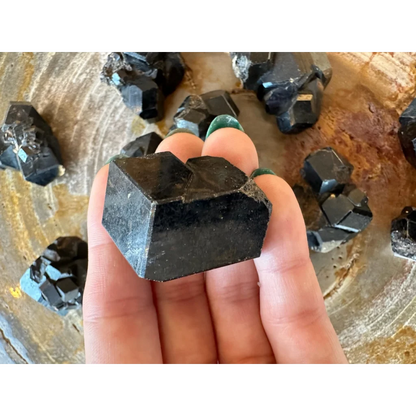 Hand holding stunning black melanite garnet crystal from Mali Africa