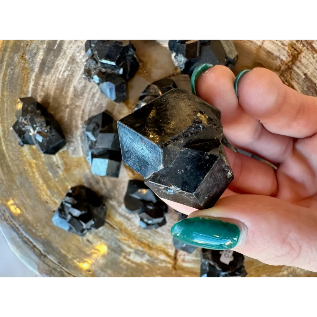 Hand holding stunning black melanite garnet crystal from Mali Africa