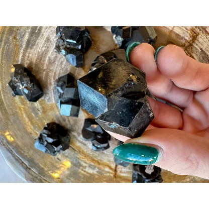 Hand holding stunning black melanite garnet crystal from Mali Africa