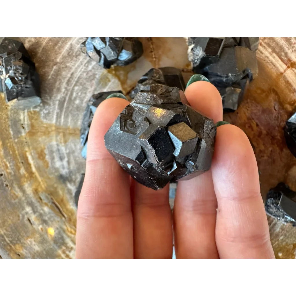 Hand holding stunning black melanite garnet crystal from Mali, Africa