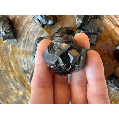 Hand holding stunning black melanite garnet crystal from Mali, Africa