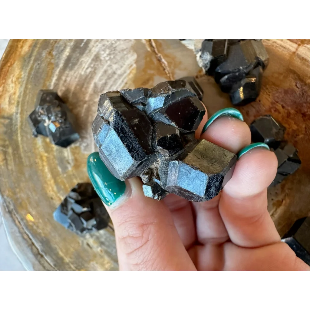 Hand holding stunning black melanite garnet crystal from Mali, Africa