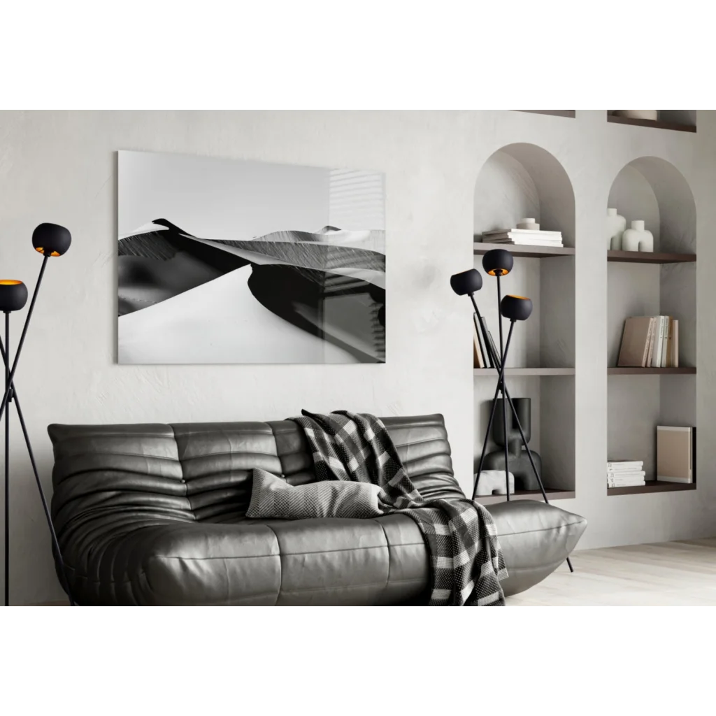 Silver leather sofa with checkered blanket and black white wall art