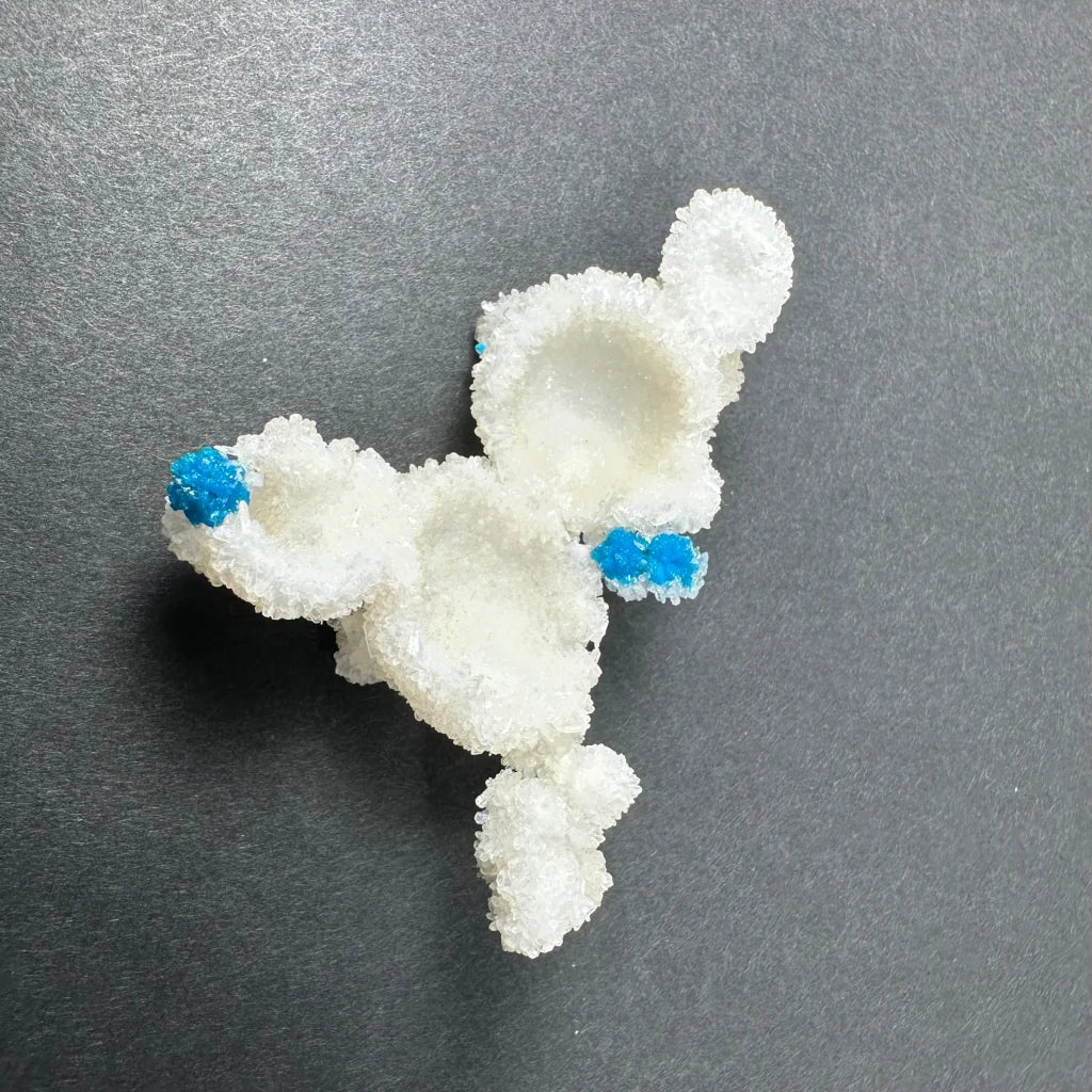 White crystalline sugar sculpture of cartoon character with blue accents on ears and paws