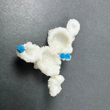 White crystalline sugar sculpture of cartoon character with blue accents on ears and paws