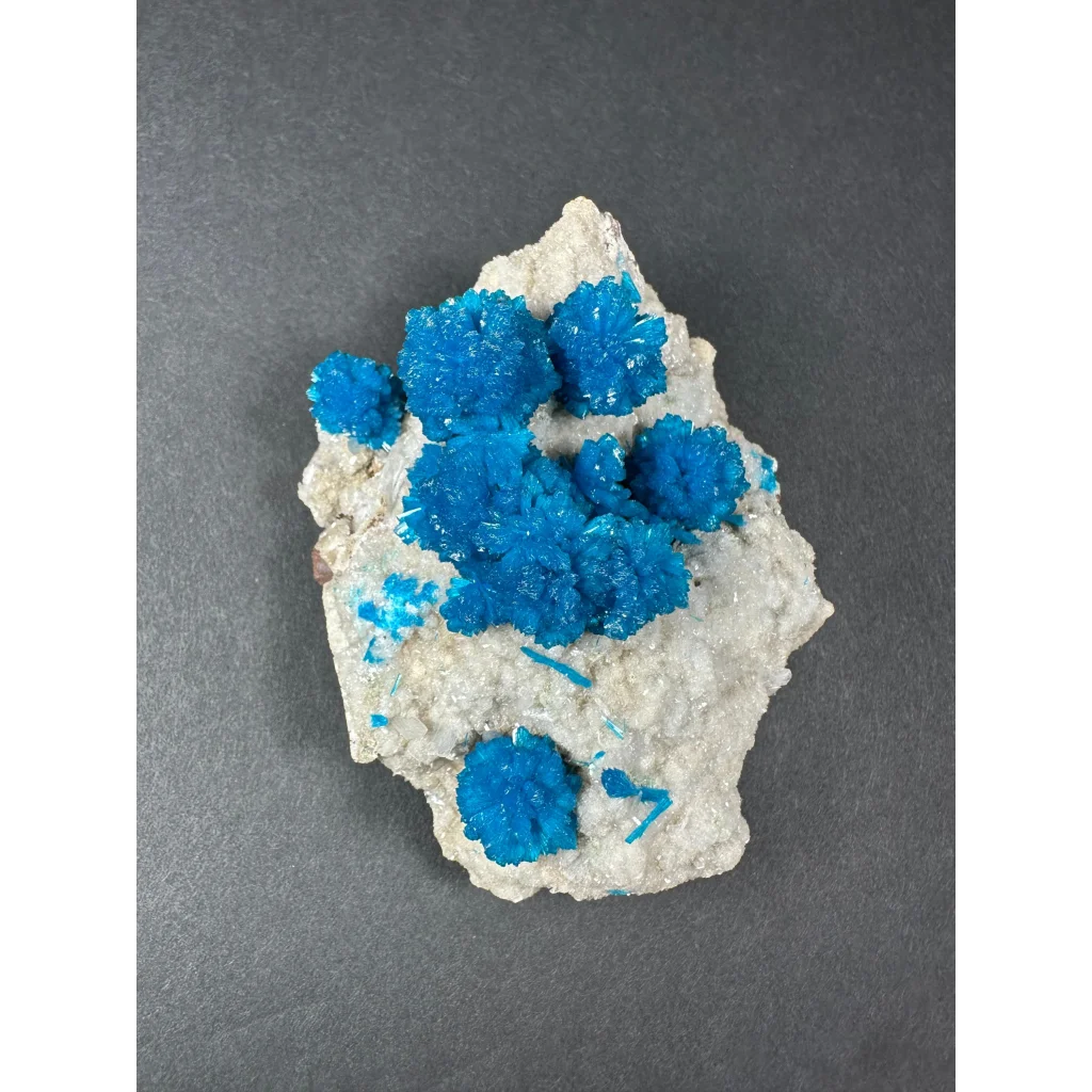 Vibrant blue cavansite crystal cluster on off-white rock from India