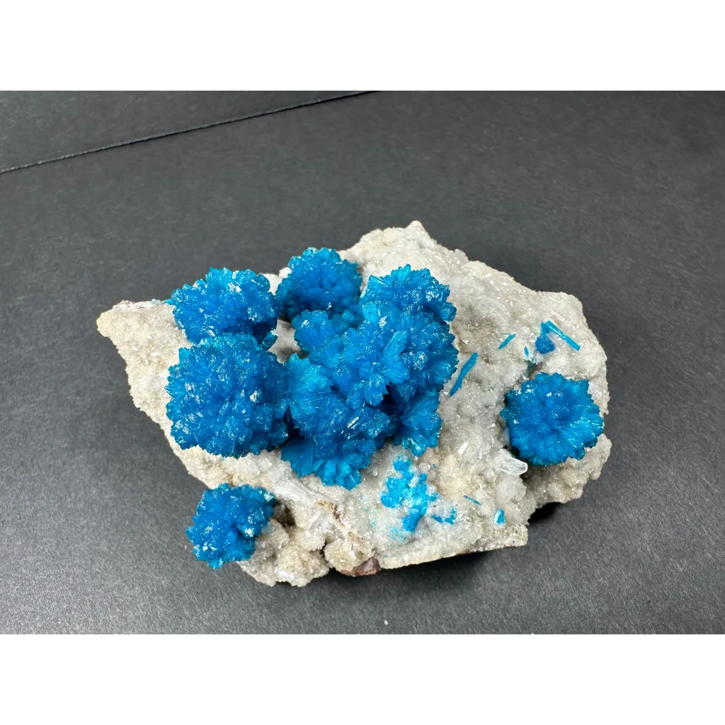 Vibrant blue cavansite crystal cluster from India on textured rock
