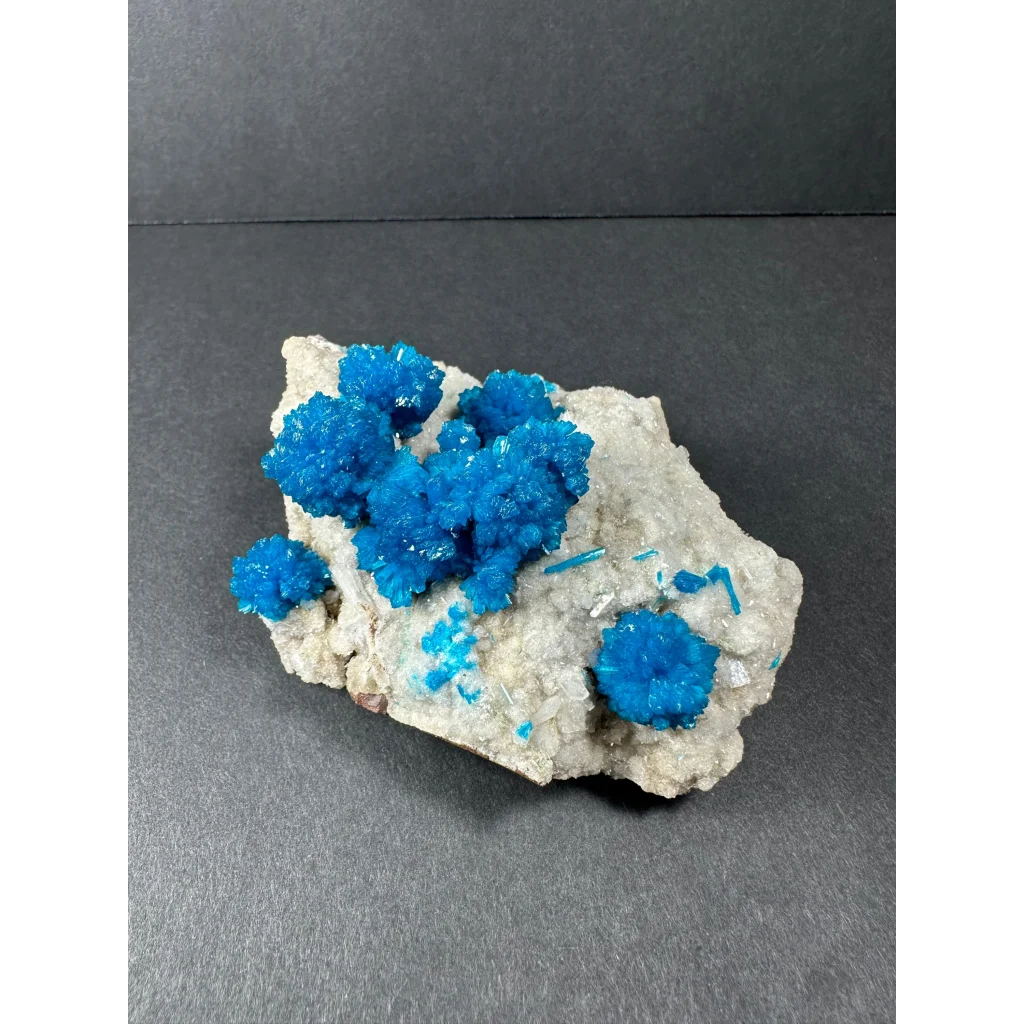 Vibrant blue copper sulfate crystals on gray rock from India