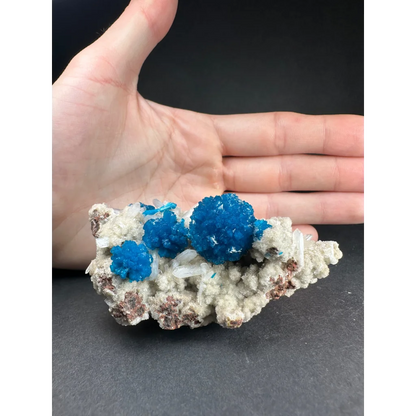 Hand holding stunning blue Cavansite crystal cluster from India