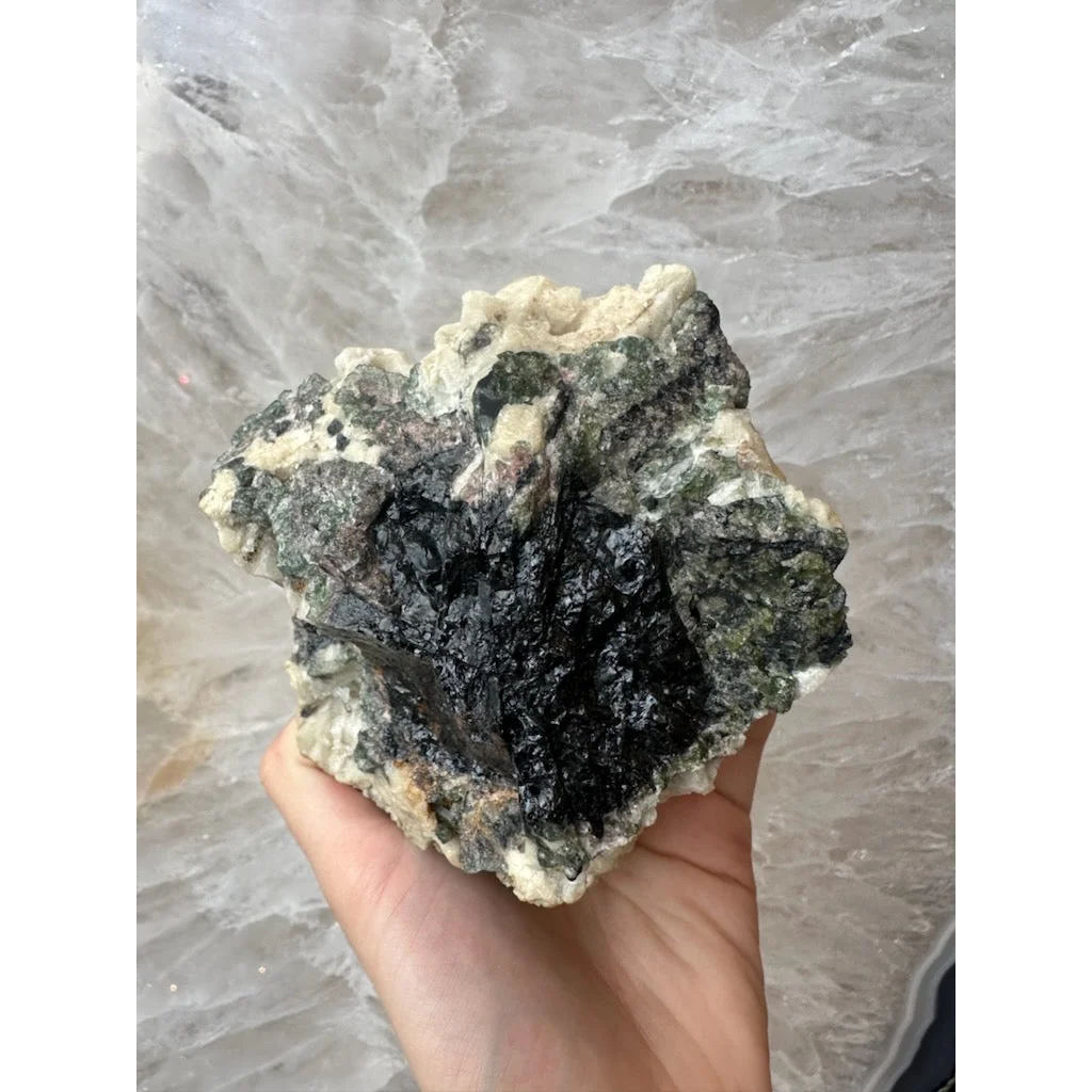 Hand holding stunning Brazilian tourmaline on albite crystal specimen