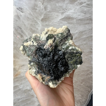 Hand holding stunning Brazilian tourmaline on albite crystal specimen
