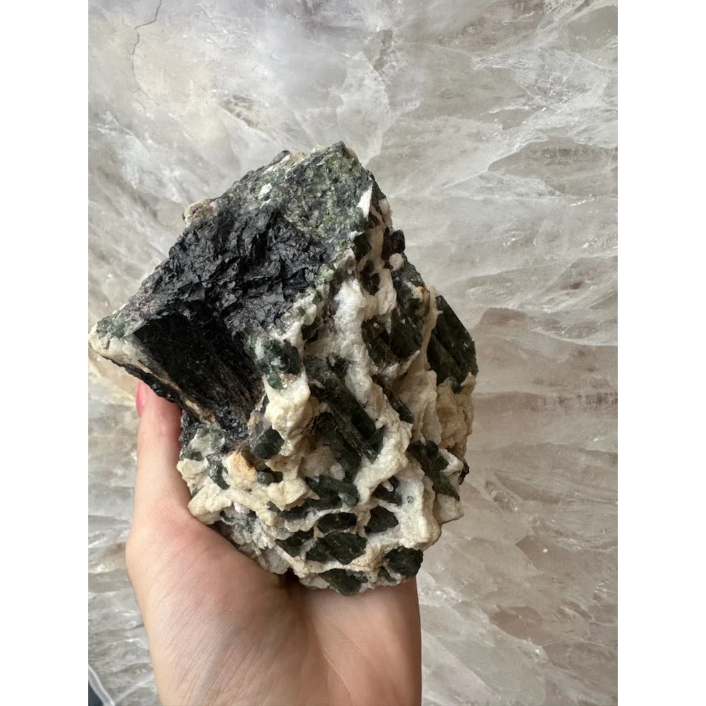 Hand holding stunning Brazilian tourmaline crystals on albite matrix