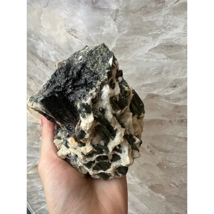 Hand holding stunning Brazilian tourmaline crystals on albite matrix