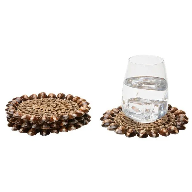 Handmade brown pandan leaf coasters with seashell accents and natural cowrie shells