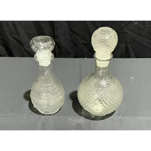 Two clear patterned crystal glass decanters with matching stoppers for your bar setup