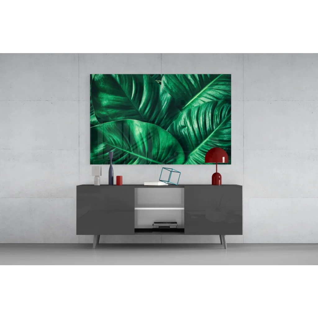 Vibrant emerald tropical leaf glass wall art above gray console