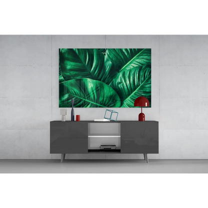 Vibrant emerald tropical leaf glass wall art above gray console