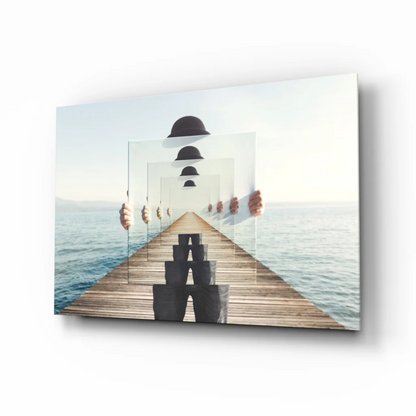 Stunning glass wall art of wooden pier with floating black cubes and ocean reflections