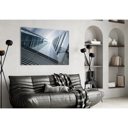 Modern black leather sofa with plaid throw and glass wall art