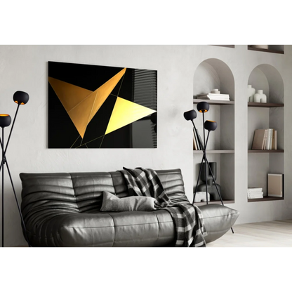 Stunning gold geometric glass wall art over black leather sofa with plaid throw