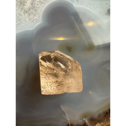 Golden topaz crystal from Shigar Valley on cloudy agate slab