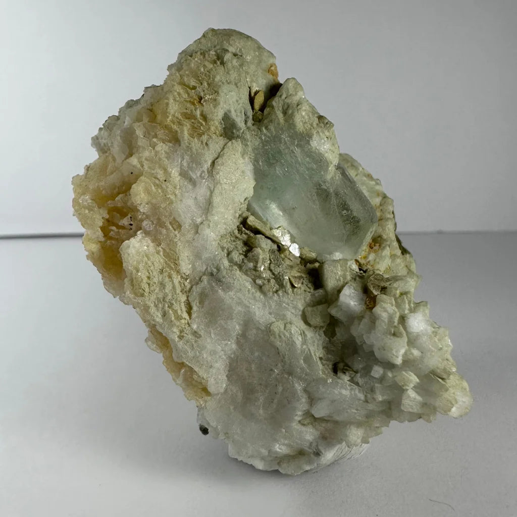 Stunning pale green quartz crystal in golden flecked rock matrix