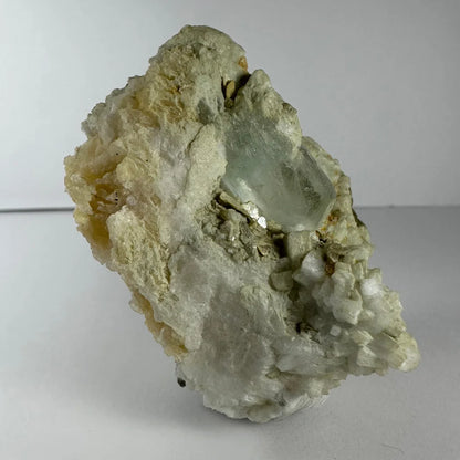 Stunning pale green quartz crystal in golden flecked rock matrix