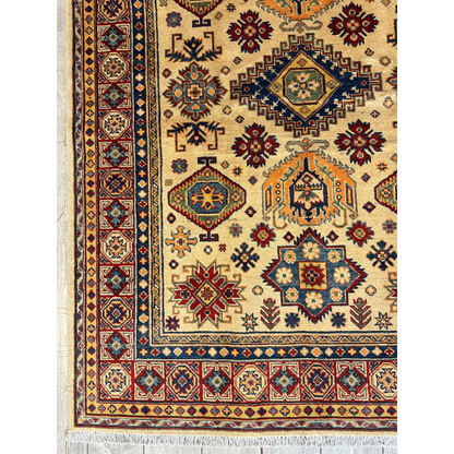 Stunning hand-knotted beige Kazak rug from Afghanistan with intricate geometric and floral patterns in deep red, navy blue, and gold accents