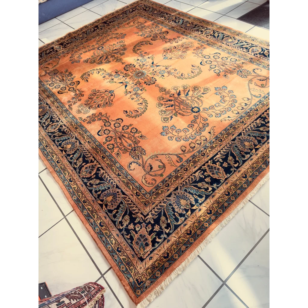 Hand-knotted wool rug with navy border and orange peach florals
