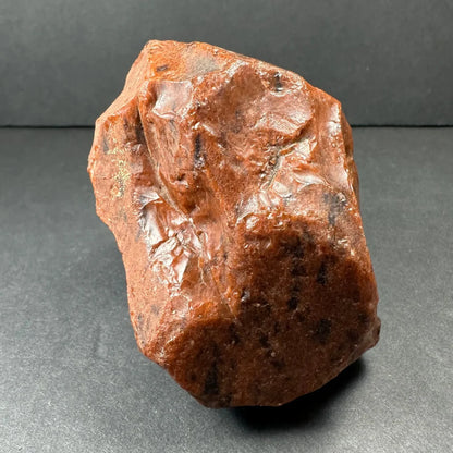 Stunning mahogany obsidian specimen, polished reddish-brown rock with glossy uneven surface and dark speckles