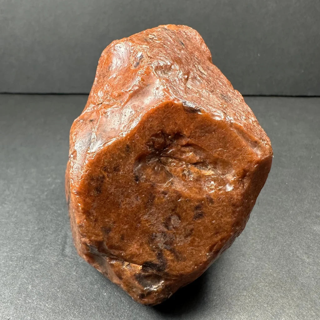 Polished mahogany obsidian stone with glossy reddish-brown surface