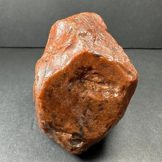Polished mahogany obsidian stone with glossy reddish-brown surface