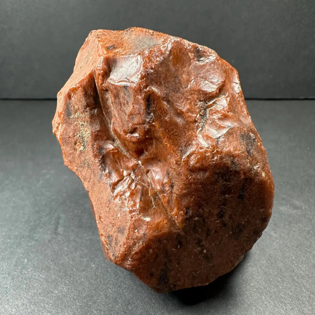 Stunning mahogany obsidian specimen with glossy reddish-brown surface and dark inclusions
