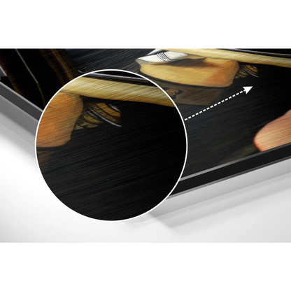 Black leather guitar pick holder with gold accents on brushed aluminium dibond