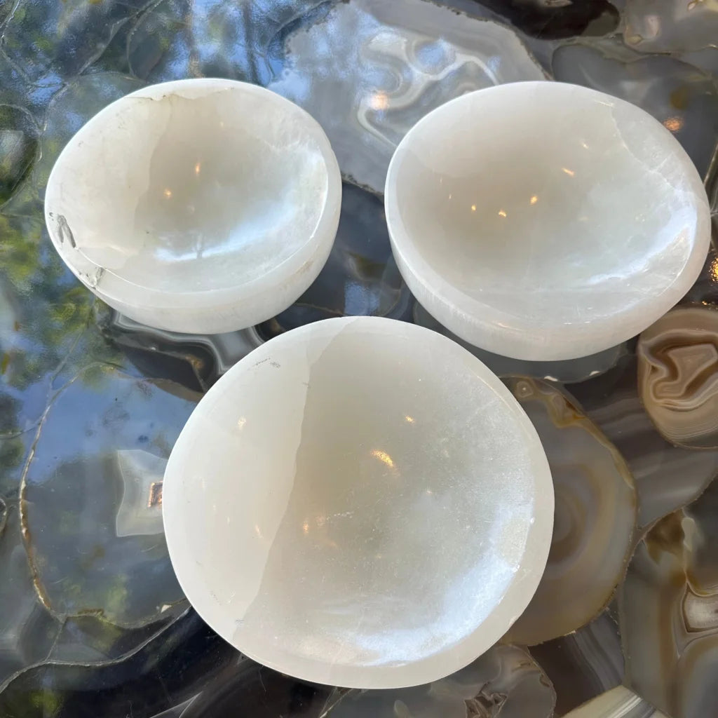 Three translucent white selenite bowls with glossy finish