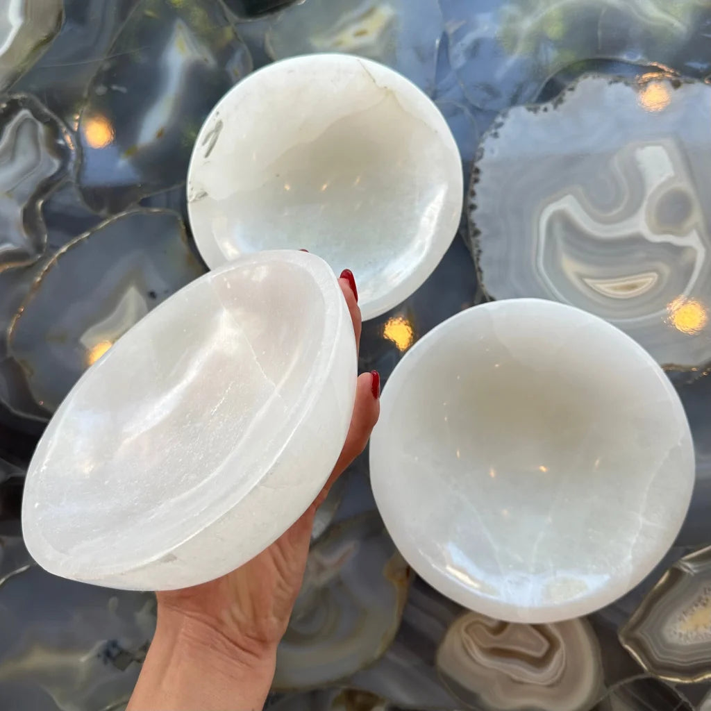 Hand holding translucent Moroccan selenite bowl with natural veining