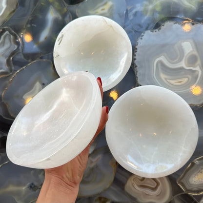Hand holding translucent Moroccan selenite bowl with natural veining