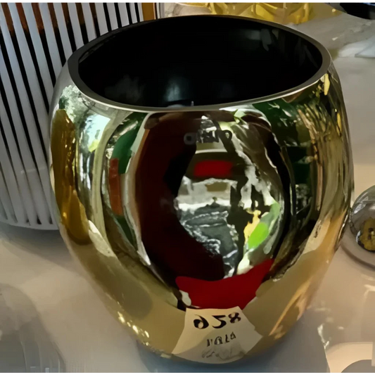 Golden Onno Cape metallic candle container with a shiny reflective finish and black interior