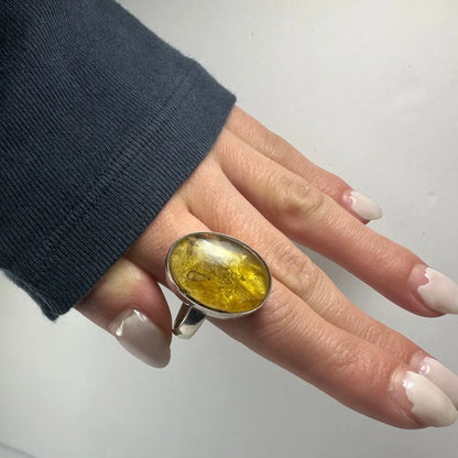 Stunning oval amber ring with golden glow on silver band