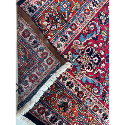 Vibrant red Persian Mashhad hand knotted wool area rug with intricate floral patterns