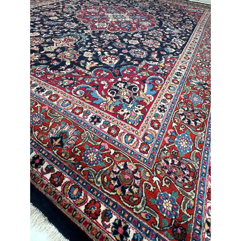 Stunning Persian Mashhad hand knotted wool area rug with navy field and floral patterns