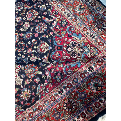 Stunning Persian Mashhad hand knotted wool area rug with navy red floral motifs