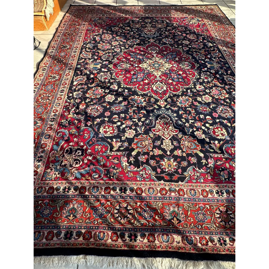 Stunning Persian Mashhad hand knotted wool area rug with black field and red medallions